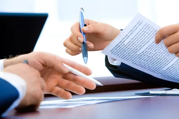شخص يوقّع مستندات على مكتب، يمثّل تحويلًا بنكيًا بغرض نظيف وسجلات محفوظة لكل عملية شراء عملات رقمية